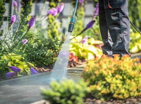 Hombre dando su servicio de jardinería en Santiago de Chile regando las plantas