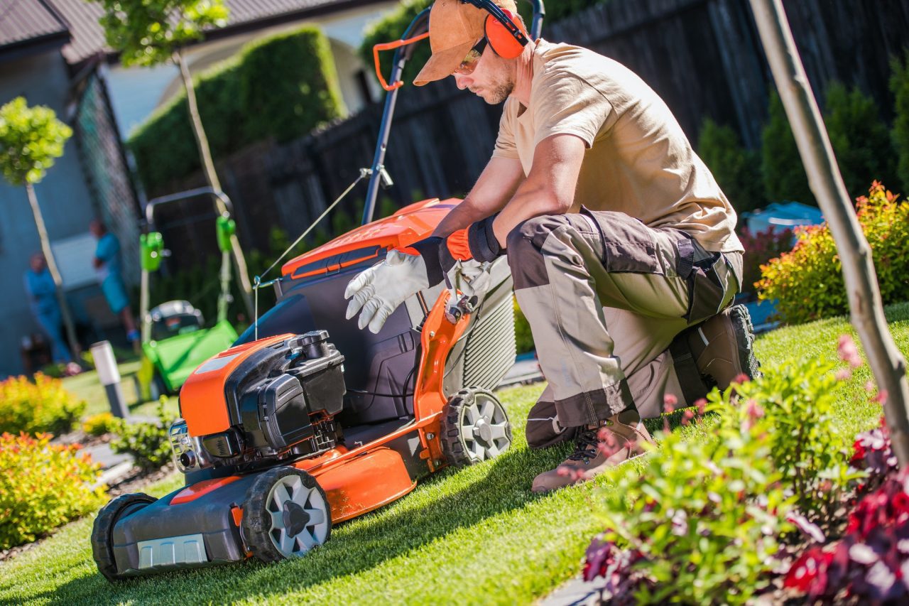 Jardinero profesional preparando cortadora de pasto para mantención de jardín en Santiago